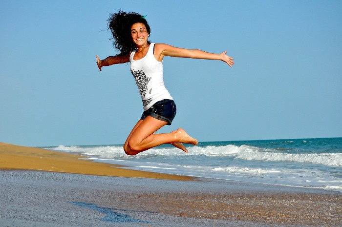 Chica saltando alegre en playa